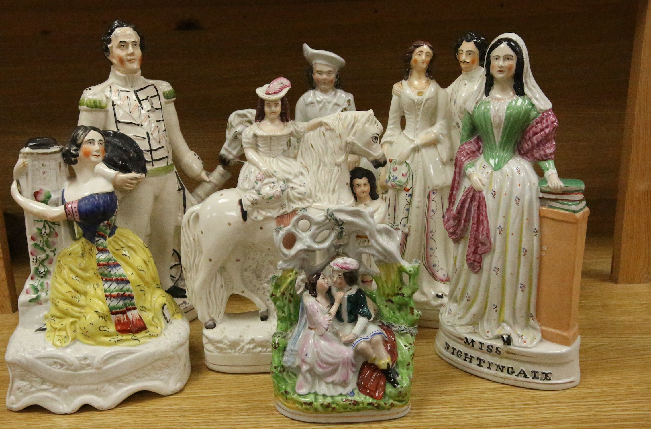 Staffordshire pottery: a bocage group, 25.5cm, 'Huntsman' 40.5cm, figure with child groom 40.5cm, figure of girl beside a column 30cm, George and Eliza Harris, 36cm, 'Dundas' beside a cannon, 40.5cm, gentleman and lady h